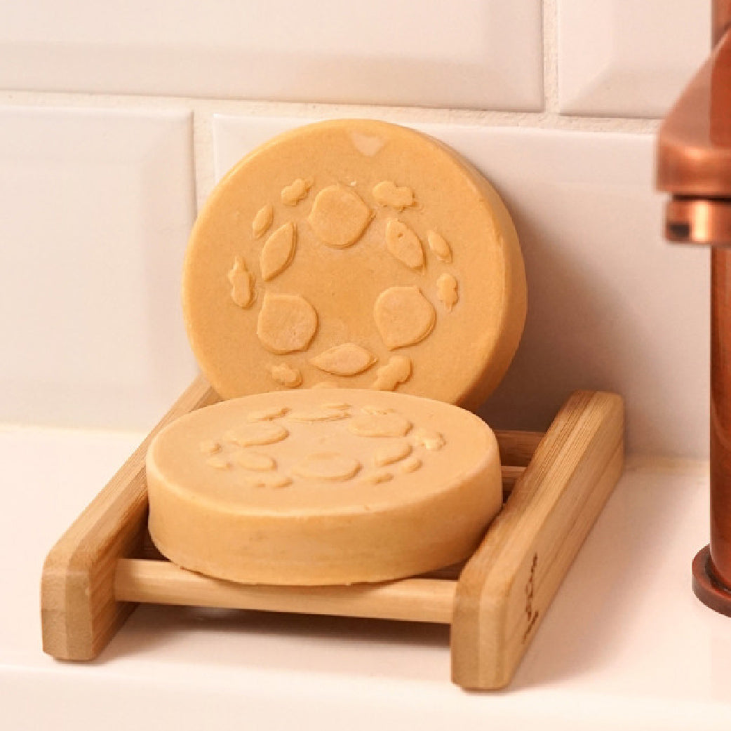 Savon solide naturel pour hygiène intime féminine sur porte-savon en bambou