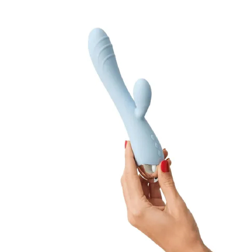 Stimulateur intime bleu clair pour bien-être féminin, tenu en main avec ongles rouges